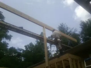 Carpenter setting a ridge beam over a new addition frame — Ice Dam Removal by Roofing Brothers in Susquehanna