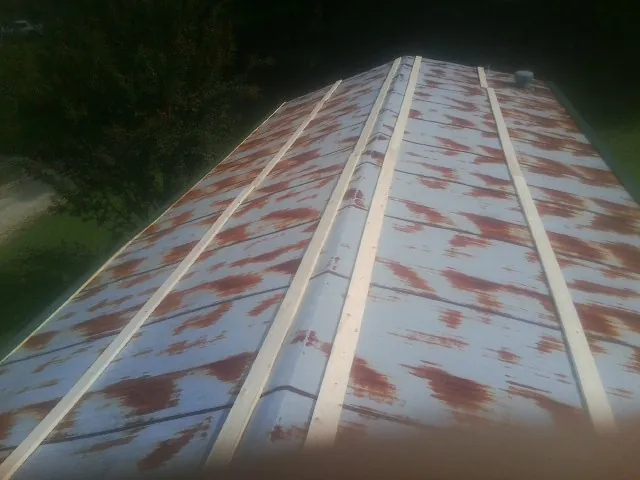 Rusted metal roof panels with new wood purlins before replacement — Storm Damage Roof Repair in Susquehanna by Roofing Brothers