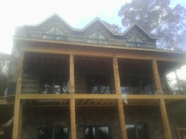 Dormers and porch framing on a large log home under construction — Roof Coating work by our crew in Susquehanna