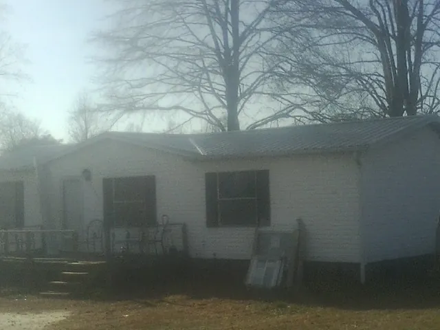 New metal roof on a white painted brick home on a foggy morning in Susquehanna