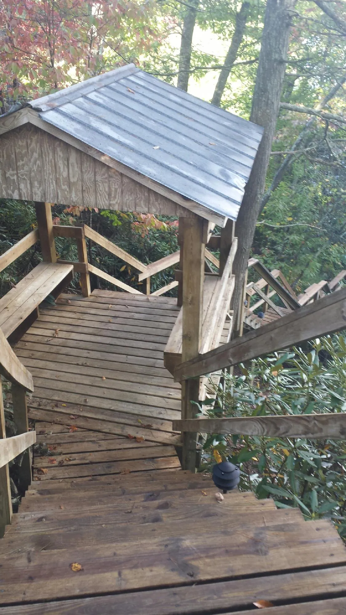 Metal roofed shelter over wooden steps on a wooded walkway — Skylight Repair & Installation work by our crew in Susquehanna